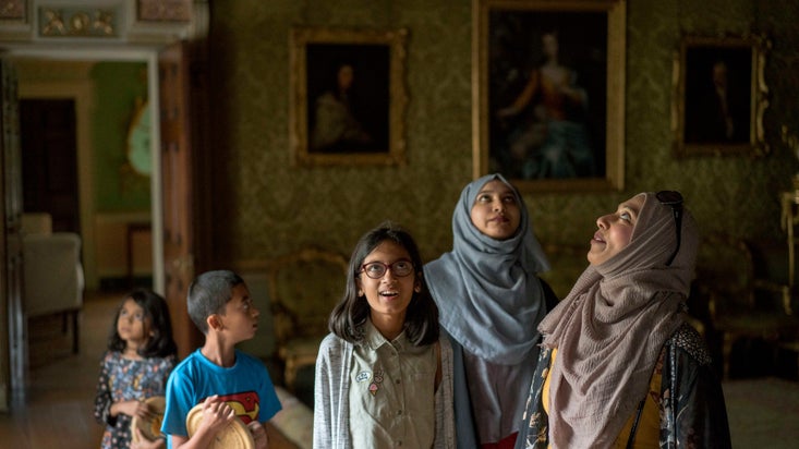 A family looking at the paintings in the Long Gallery at Osterley Park in London